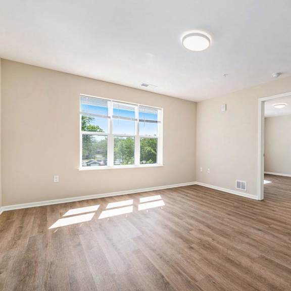 A room with wooden floors and a large window.