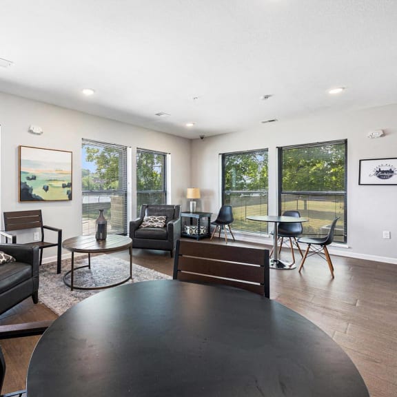 a living room with couches and a table    and large windows