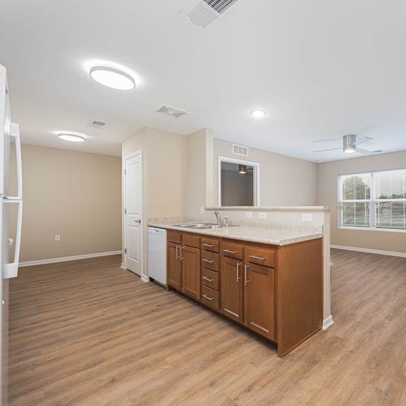 A kitchen with wooden floors and white appliances.