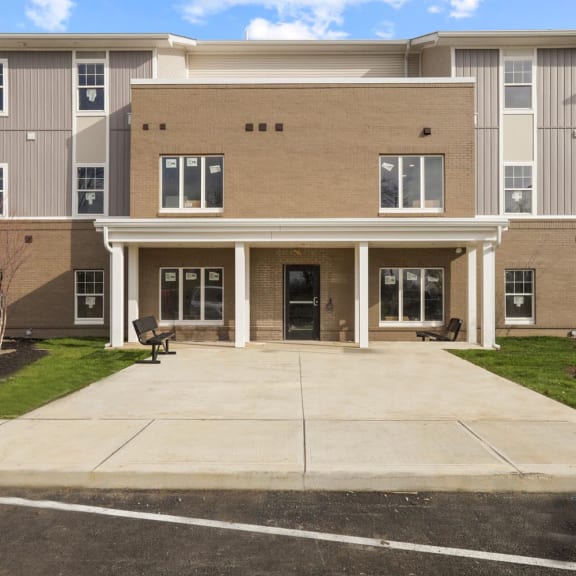 a large apartment building with a driveway and grass