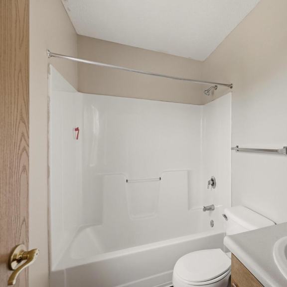A white bathroom with a toilet, sink, and bathtub.