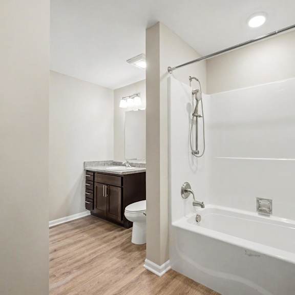 A white bathroom with a tub, toilet, and sink.