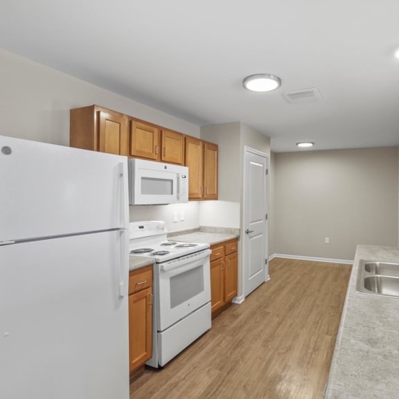 a kitchen with white appliances and wooden cabinets