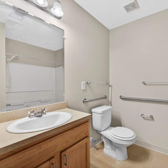 A white toilet sits next to a white sink in a bathroom.