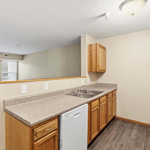 A large empty room with a carpeted floor and a door leading to a balcony.