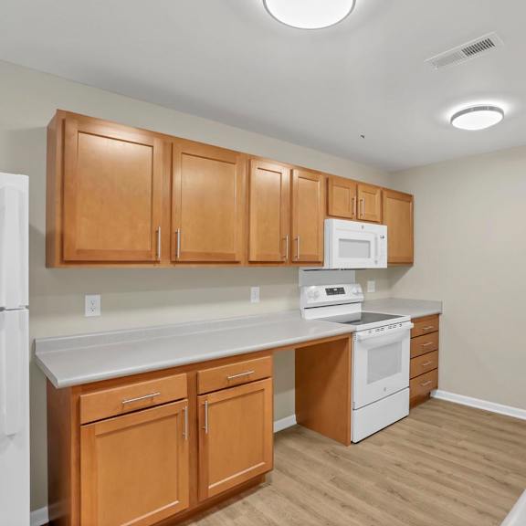 A kitchen with wooden cabinets and white appliances.