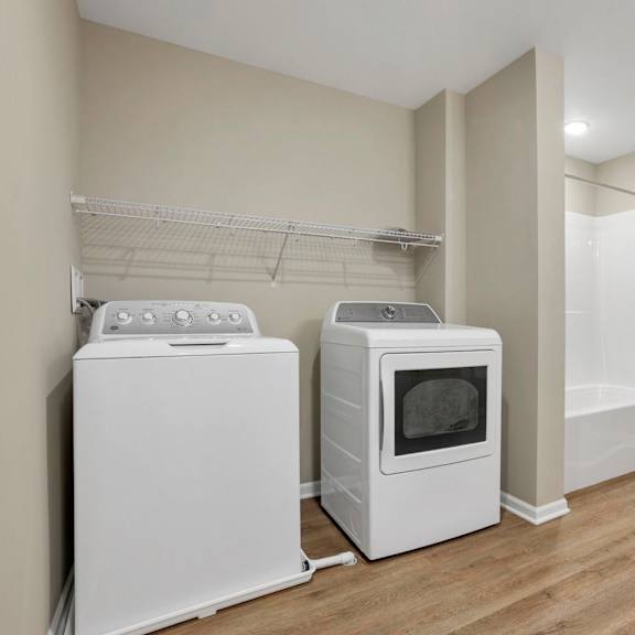 A small room with a microwave, oven, and a shower.