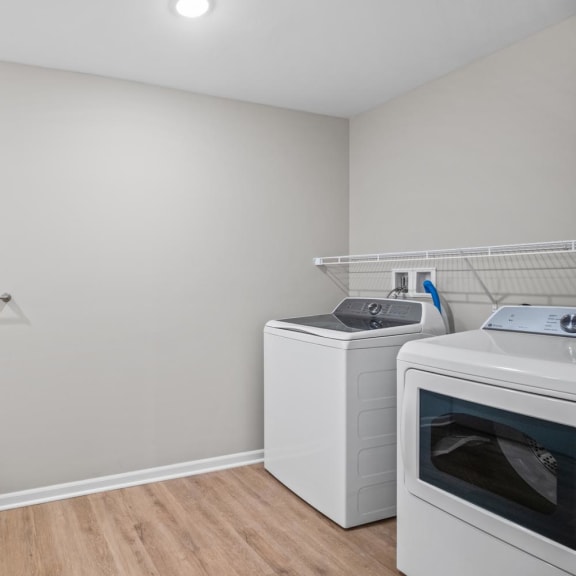 an empty laundry room with two washes and a dryer in it