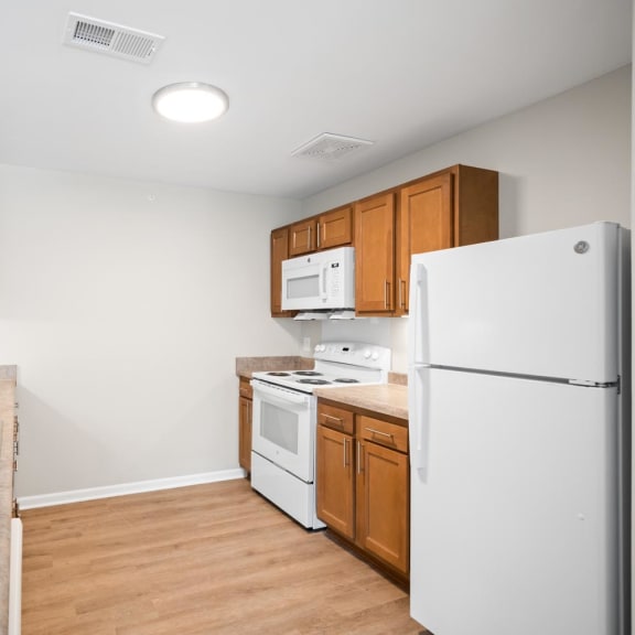 a kitchen with white appliances and wooden cabinets