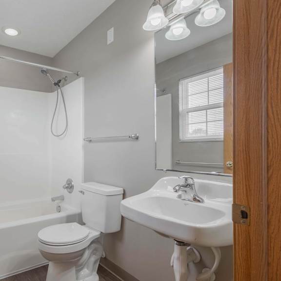 A white toilet sits next to a white sink in a bathroom.