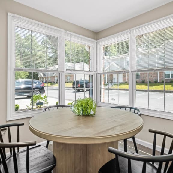 a dining room with large windows and a table with chairs