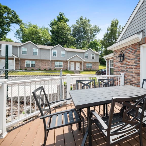 a patio with a table and chairs on a deck