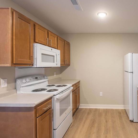 A kitchen with wooden cabinets and white appliances.