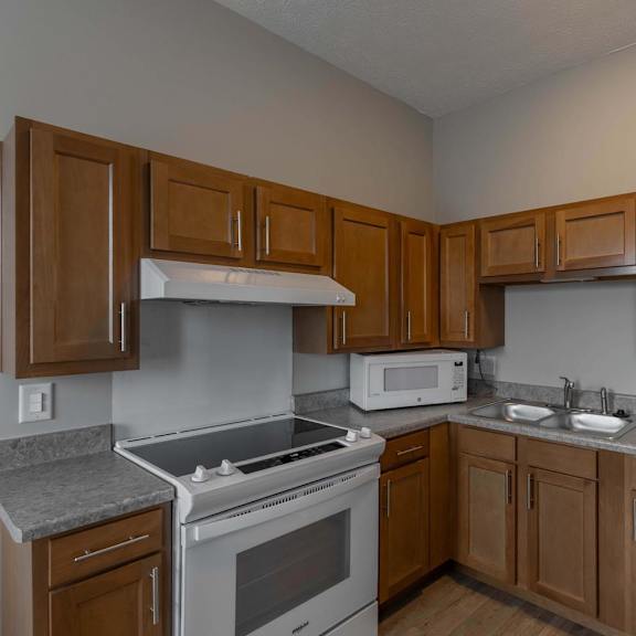 A kitchen with a white refrigerator, white stove, and white microwave.