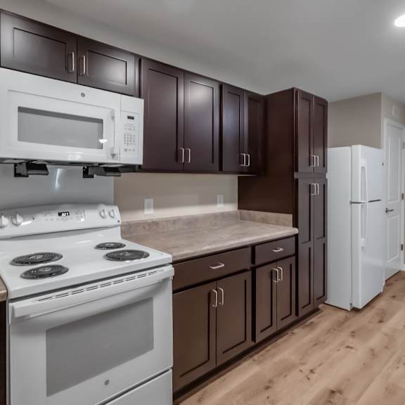 A kitchen with a white stove and microwave above a white oven.