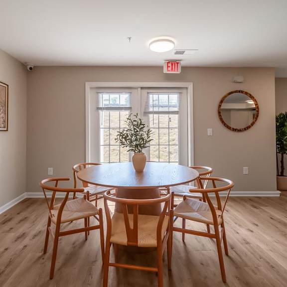 A dining room with a round table and chairs.