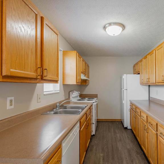 A kitchen with wooden cabinets and a white refrigerator.