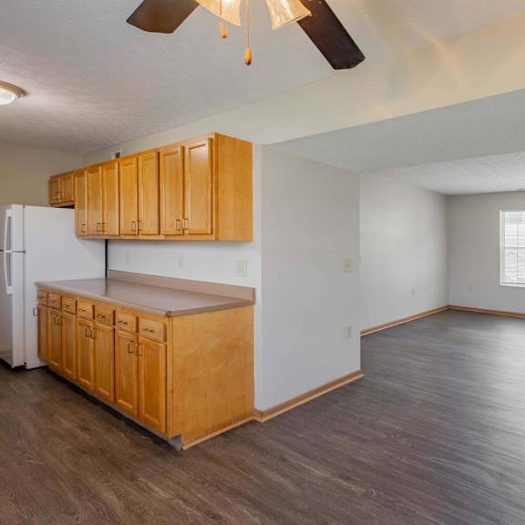 A kitchen with wooden cabinets and a refrigerator.