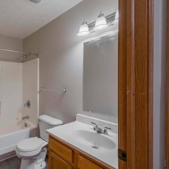 A bathroom with a toilet, sink, and bathtub.
