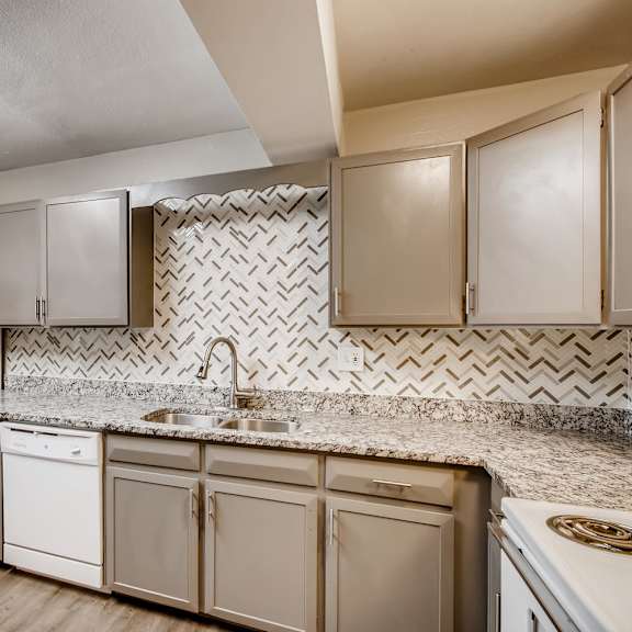 A kitchen with white appliances and cabinets.