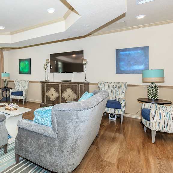 an open concept living room and dining area with a white dining table and rattan chairs