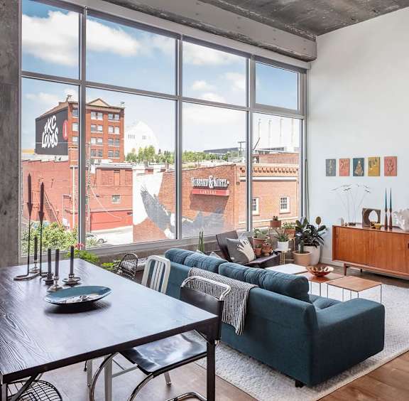A living room with a view of the city through large windows.