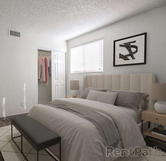 A bedroom with a large bed and a bench in front of it.