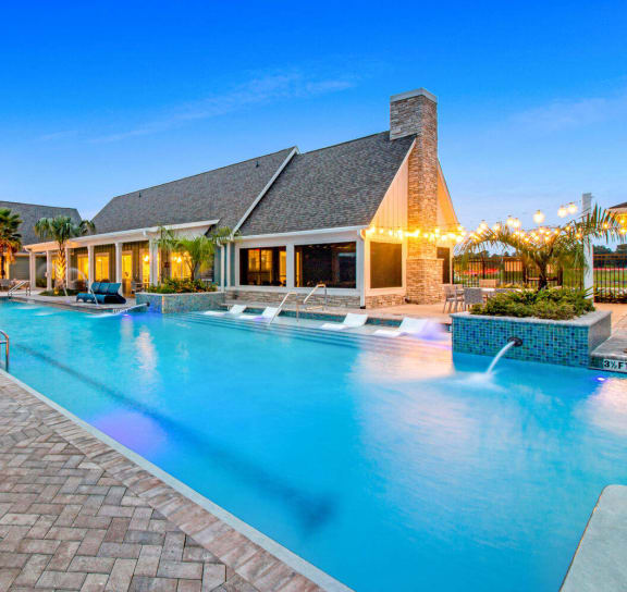 a swimming pool with lounge chairs in front of a building at Watermark at Urban Blu, Panama City Beach, Florida