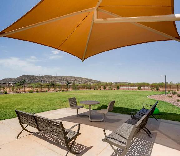 A patio with a table and chairs under a large umbrella.