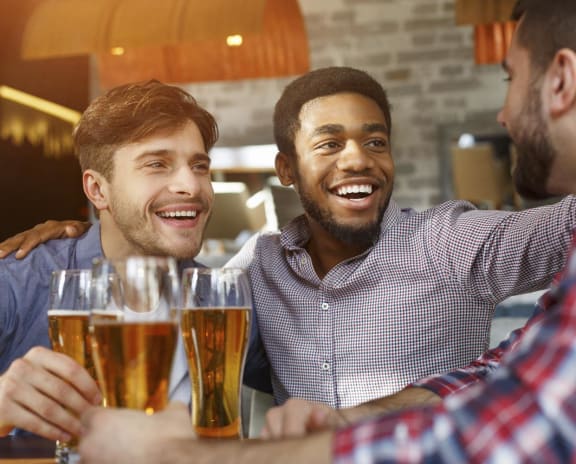 group of men sitting at a table with glasses of beer