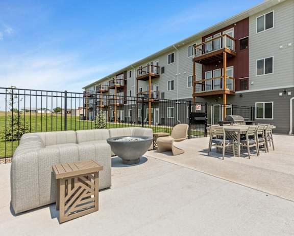 our apartments have a large patio with furniture and a fire pit