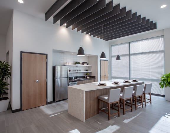 a large kitchen with a long island with chairs and a dining table