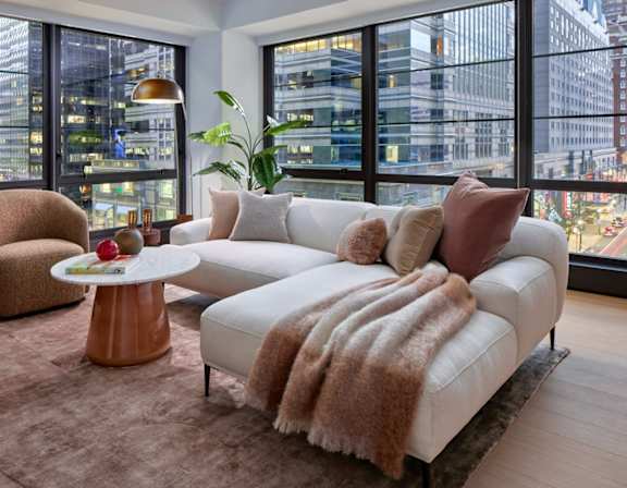 A modern living room with a large window overlooking a cityscape.