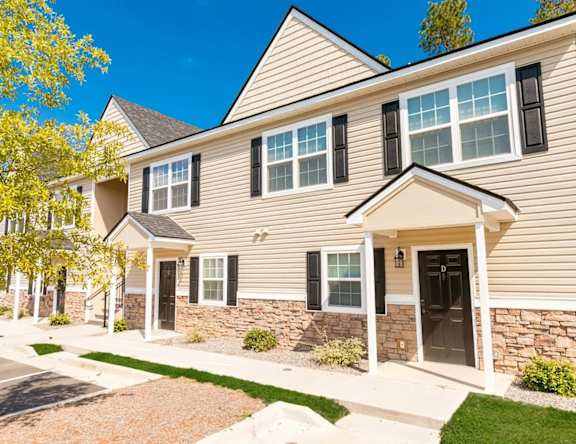 A house with a stone wall and a black door.