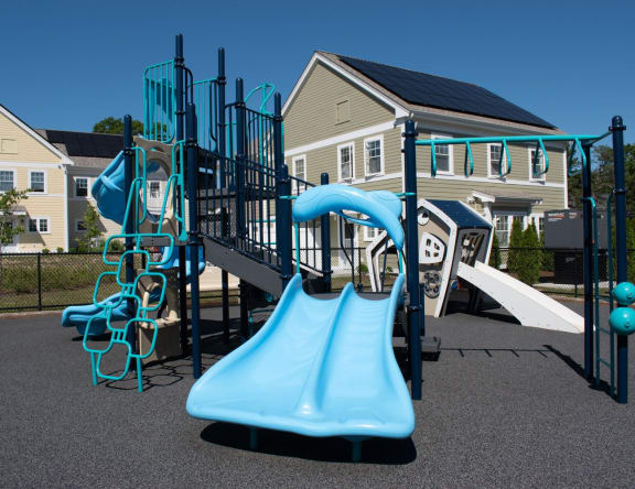 a playground with a blue slide and climbing equipment