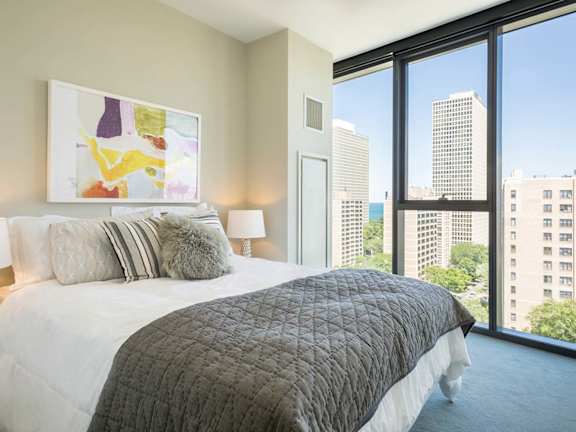 A bedroom with a large bed and a view of the city.
