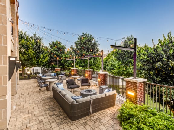 a patio with couches and chairs and a fire pit