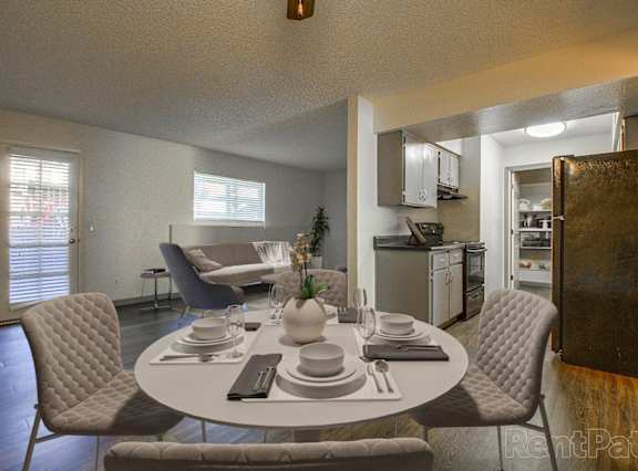A dining room with a round table set for four.