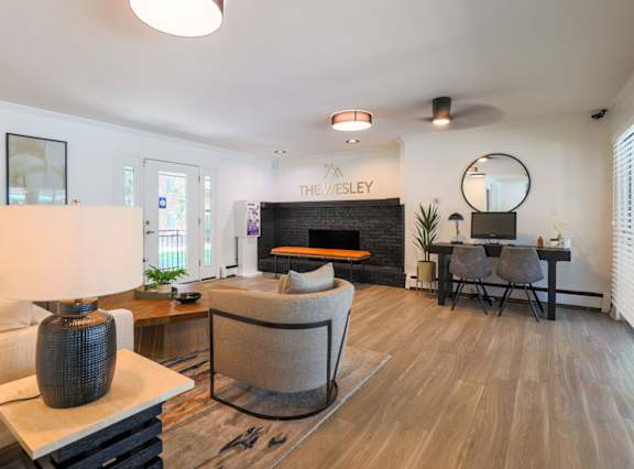 a living room with a couch and a chair and a fireplace at The Wesley Apartments, Denver, CO 80222