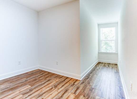 A room with wooden flooring and a window.