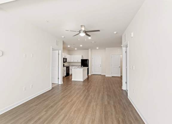 Peaks of Lexington Apartments Kitchen with Black Appliances, Granite Countertops and White Cabinetry and connected living room
