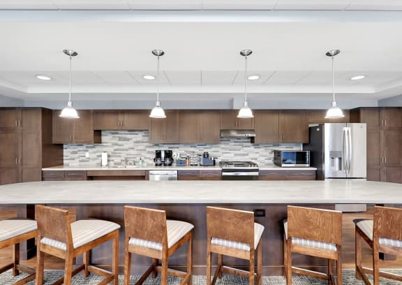 a kitchen with a large island with chairs and a counter