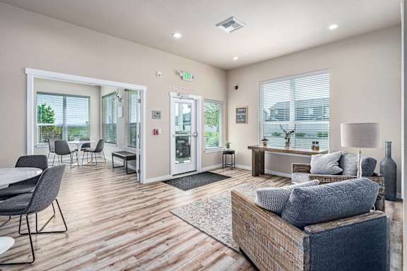 A living room with a grey couch and a wooden floor.