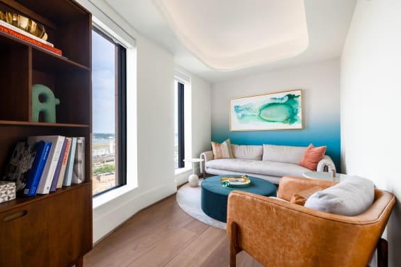 a living room with a blue accent wall and a white couch at The Grace and Reva, Virginia, 22202