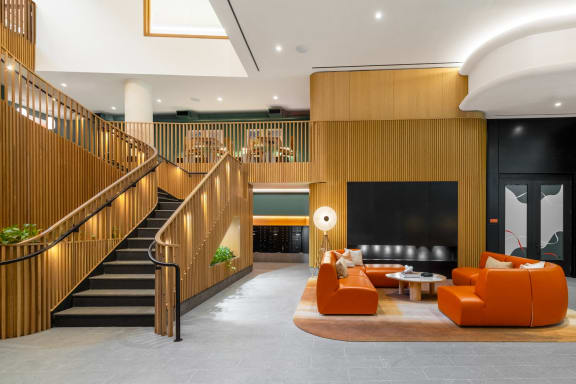 a lobby with orange furniture and a staircase at The Grace and Reva, Arlington, 22202