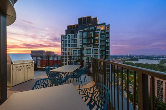 a balcony with a view of a city and a sunset at The Grace and Reva, Arlington, 22202