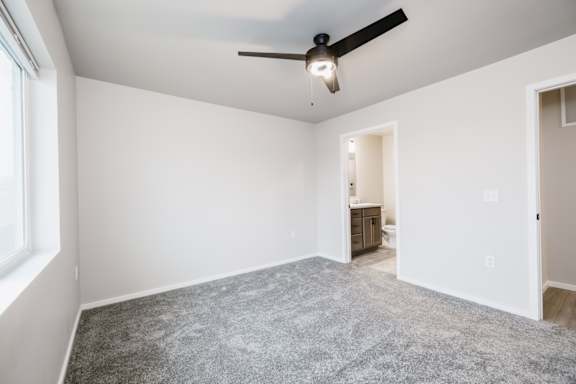 A room with a ceiling fan and a carpeted floor.