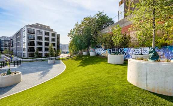 a park with green grass and a building in the background at Coda at Bryant Street, Washington, DC 20002