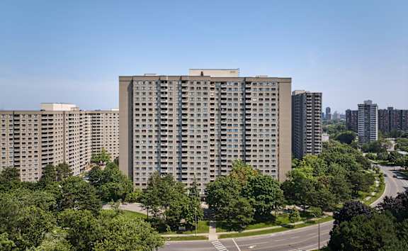 A large building with a lot of windows is surrounded by trees.