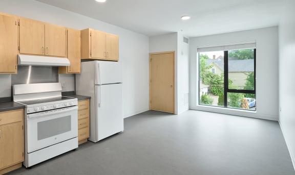 a kitchen with a white stove top oven next to a window